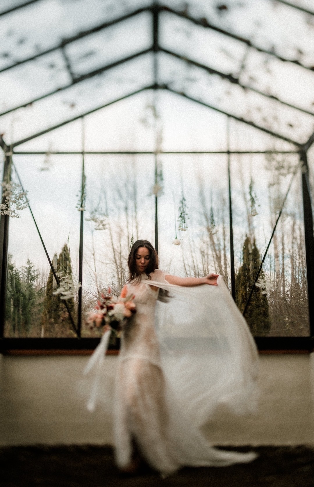 Bride twirling in her dress inside the glass greenhouse at FernHaus